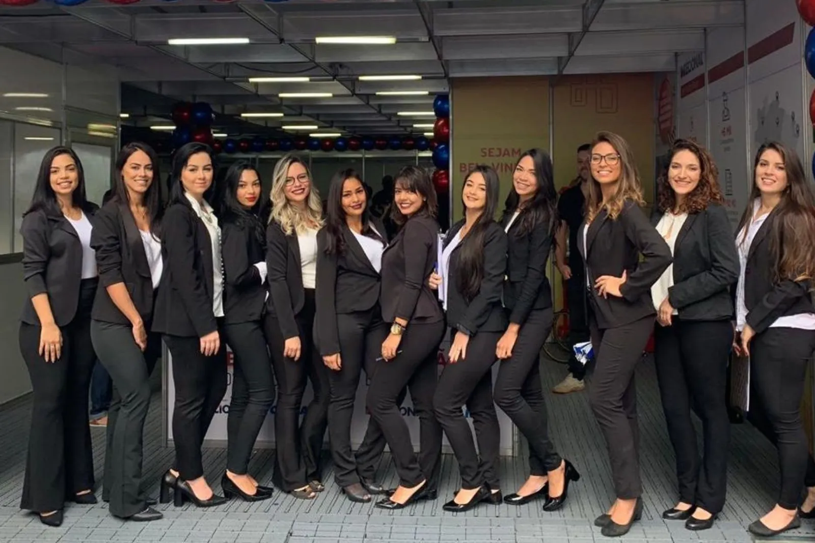 Equipe de recepcionistas da Flow Time uniformizada e posicionada em stand de lançamento imobiliário