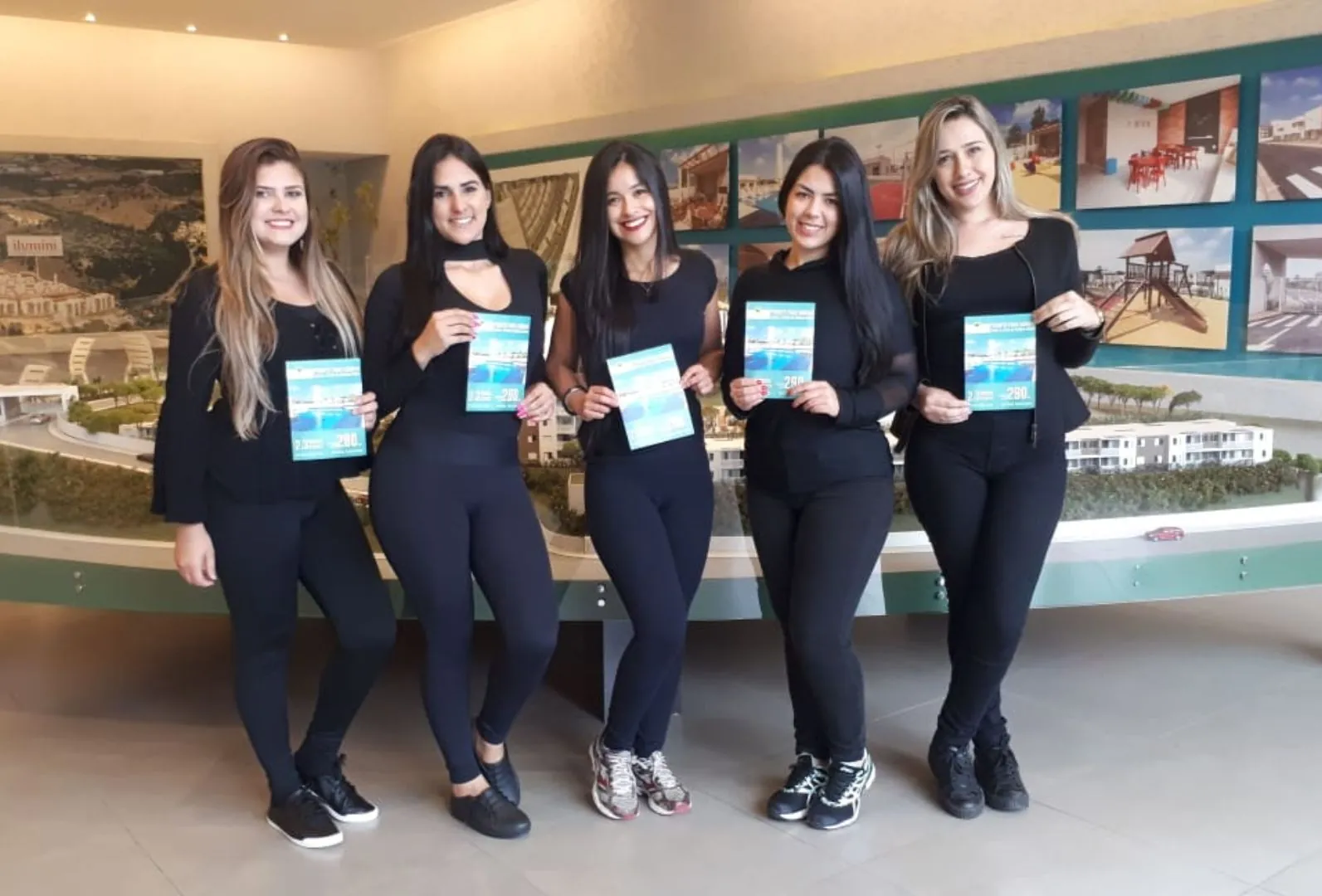 Equipe de recepção da Flow Time apresentando materiais do empreendimento aos visitantes